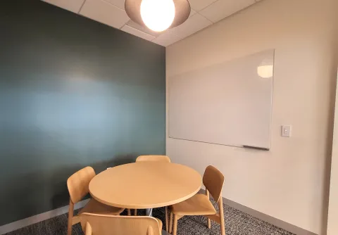 Photo of study room with table, chairs, and whiteboard visible. 